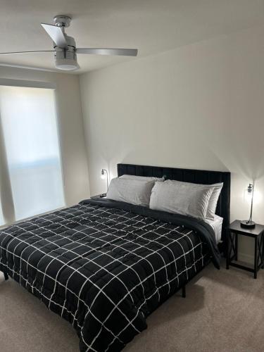 una camera da letto con un letto con una coperta a quadri in bianco e nero di Luxe Mid-Downtown apartment a Houston