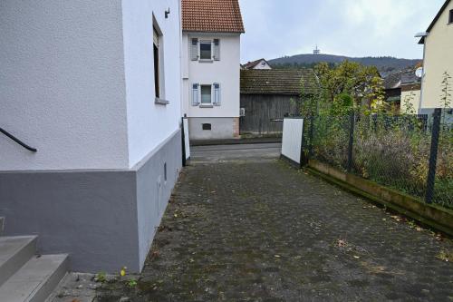 an empty alley with a white building and a fence at bee Apartment 10 Betten für Gruppen & Monteure PS5 in Fellingshausen