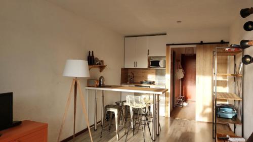 - une cuisine avec un comptoir et quelques chaises dans l'établissement Studio aux pieds des pistes - Le Balcon de Villard, à Villard-de-Lans