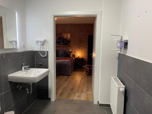 a bathroom with a sink and a room with a bed at Wild West Appartement in Bad Salzuflen