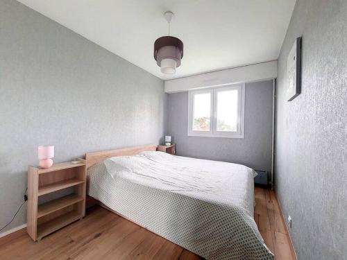 une chambre avec un lit blanc et une fenêtre dans l'établissement appartement accès direct mer classé 3*, à Cabourg