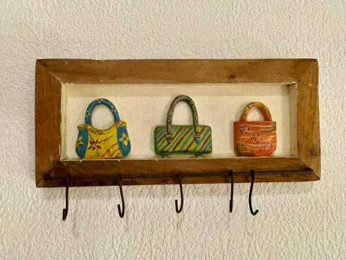 a shelf with four handbags on a wall at Pousada Rosa dos Ventos in Praia do Forte