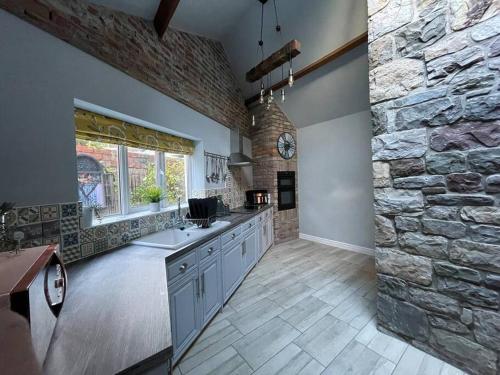 uma grande cozinha com uma parede de pedra em Bridgend Cottage em Abercraf