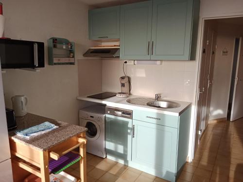 een keuken met een wastafel en een wasmachine bij Superbe appartement avec vue sur la mer et port in Frontignan