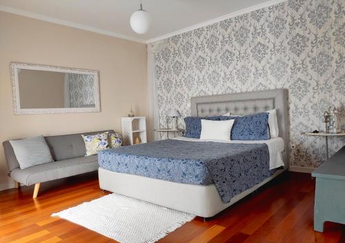 1 dormitorio con 1 cama y 1 sofá en bluegreen en Arco da Calheta