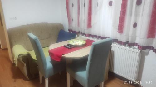einen kleinen Tisch mit zwei Stühlen und eine Schüssel darauf in der Unterkunft Apartman.nemanjica bb in Nevesinje