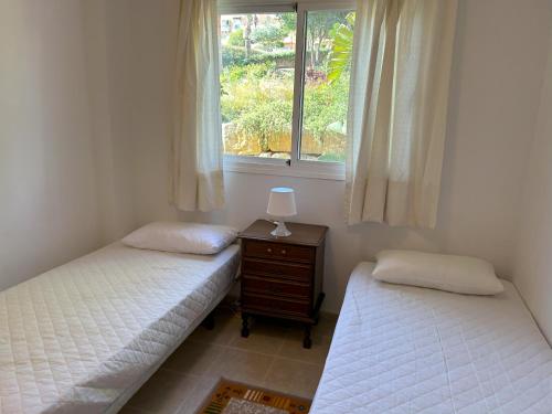 - 2 lits jumeaux dans une chambre avec fenêtre dans l'établissement Casares Del Sol Apartment Pearl, à Bahia de Casares
