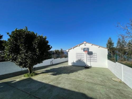 a white building with a basketball hoop at Casa a la orilla del mar in Neda
