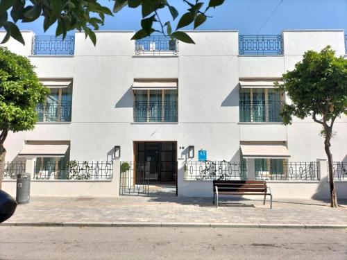 a building with a bench in front of it at Apartamentos Turísticos La Plaza in Chipiona