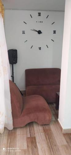 a couch with a clock on the wall at Apartamentos WilMoni in Turbo