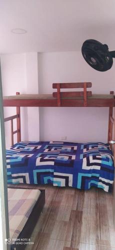 a bedroom with a bunk bed with a blue and black comforter at Apartamentos WilMoni in Turbo