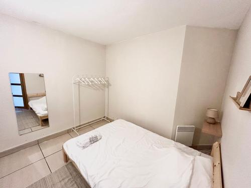 a small room with a bed and a mirror at Chambre proche de Genève in Annemasse