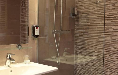 La salle de bains est pourvue d'une douche, d'un lavabo et d'un téléphone. dans l'établissement Hôtel Morphée Lille Villeneuve d'Ascq, à Villeneuve d'Ascq