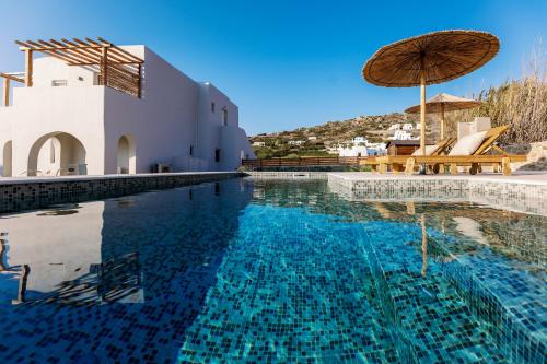 una piscina con sedie e ombrellone accanto a un edificio di Villa Finest -Seaside Villa with private swimming pool- a Mikri Vigla