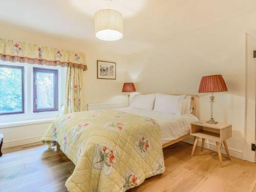 a bedroom with a bed and a table with a lamp at Mulberry Cottage in Bakewell