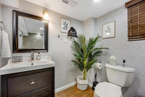 a bathroom with a sink and a toilet and a plant at The Logandale: HUGE Mid-Century Home, sleeps 15 in Chicago