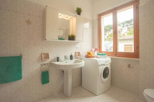 a bathroom with a washing machine and a sink at Maria Vittoria in Campese