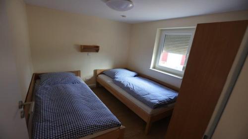 a small room with two beds and a window at Feriendorf am Flämingbad in Coswig