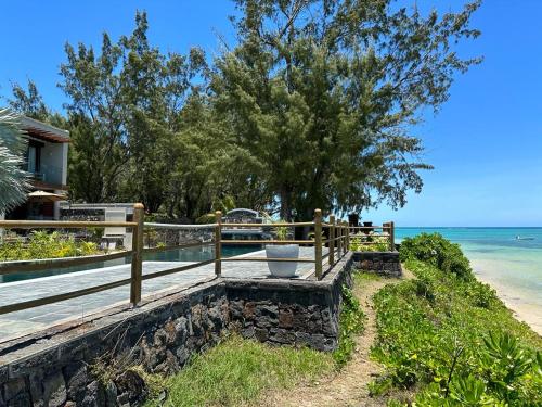a wooden bench next to the beach at Idyllic Beach Apartment in Bain Boeuf