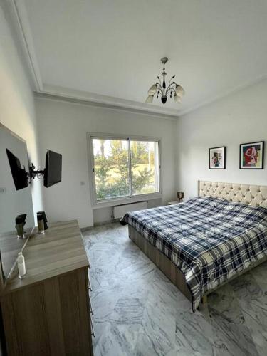 1 dormitorio con cama, mesa y ventana en Appart Cosy pieds dans l'eau au coeur de Kantaoui en Sousse