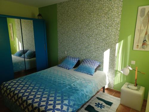 een slaapkamer met een blauw bed en een spiegel bij Chambre Cosy in Nîmes