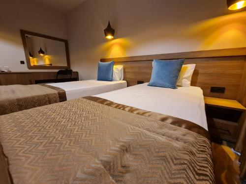 Un pat sau paturi într-o cameră la Hotel Angro Palace