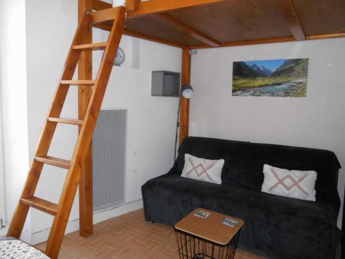 een woonkamer met een zwarte bank en een houten ladder bij Appartement WIFI Monné centre Cauterets in Cauterets
