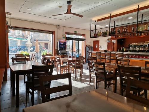 a restaurant with tables and chairs and a bar at Apartamento Rural La Plaza Vieja in Viver