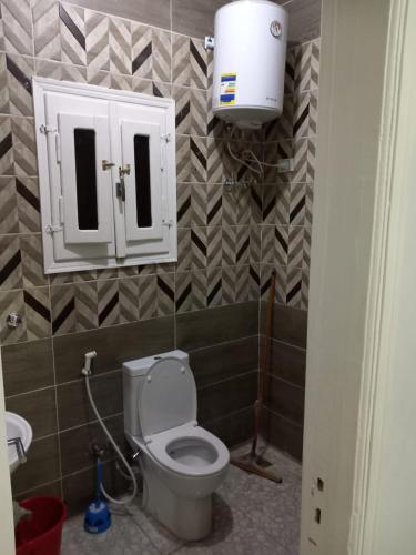 uma casa de banho com um WC, um lavatório e um armário em Ikea flat 6 em Hurghada