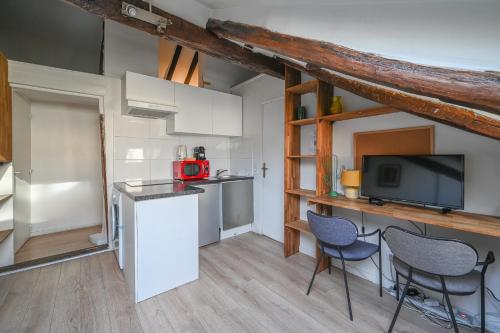 - une cuisine avec un comptoir et des chaises dans la chambre dans l'établissement Cléry 58, à Paris