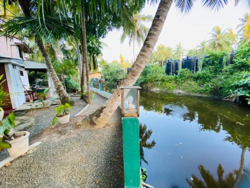 a green pole next to a river with palm trees at The River Villa in Talpe
