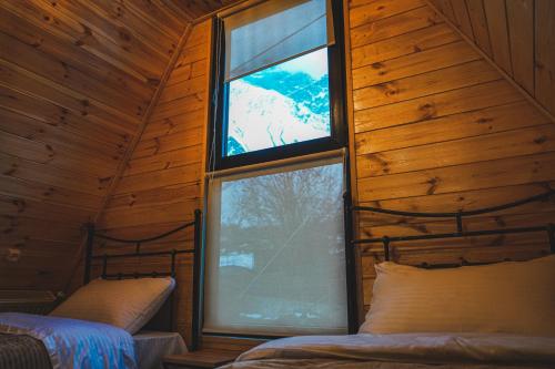 a room with two beds and a window in a cabin at Morning Star Kazbegi in Kazbegi