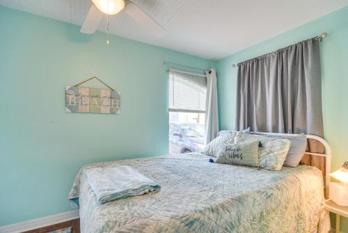 um quarto com uma cama com paredes azuis e uma janela em St Pete Beach Apt Near Shopping Walk to Ocean! em St. Pete Beach