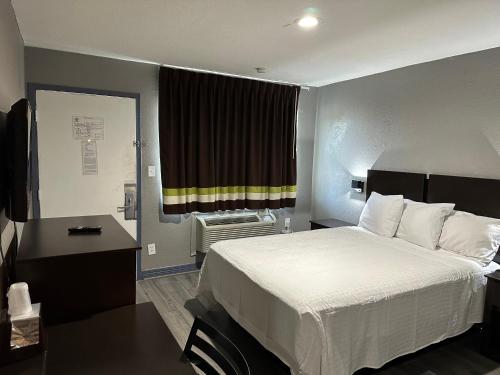 a hotel room with a large bed and a window at Americas Best Value Inn and Suites Groves in Groves