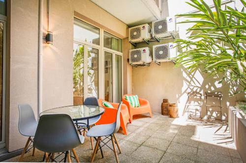 a patio with a glass table and chairs at Alegria Colour Apartments in Porto