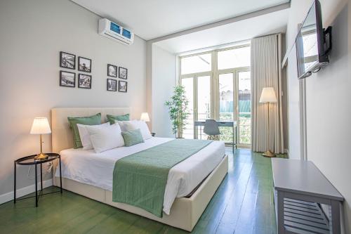 a bedroom with a bed and a television in it at Alegria Colour Apartments in Porto