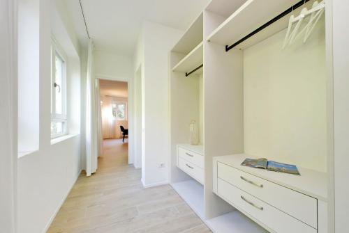 une cuisine avec des placards blancs et un couloir dans l'établissement Siena Hills Apartments, à Sienne