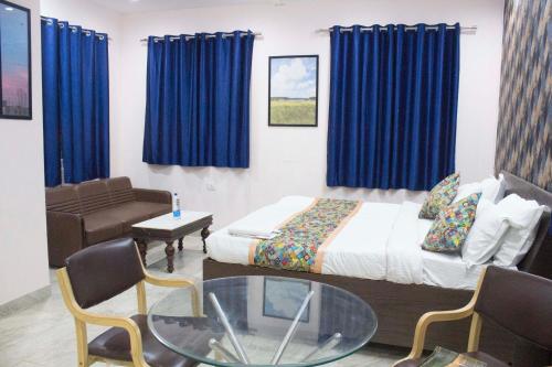 una camera con letto, divano e tavolo in vetro di JSB HOTEL a Faridabad