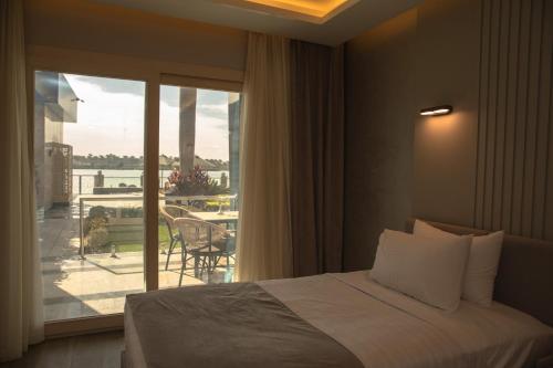 a bedroom with a bed and a view of a balcony at Nile Club hotel in Cairo
