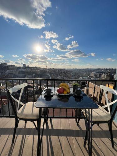 una mesa con un bol de fruta en el balcón en Taksim Larissa hotel suites, en Estambul