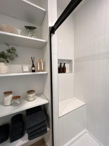 a bathroom with a shower with white tiles at Coastal Cottage By Vilano in St. Augustine