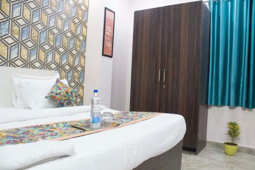 a hotel room with a bed with a bottle of water on a tray at JSB HOTEL in Faridabad