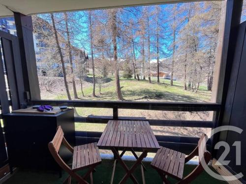 une table et deux chaises devant une fenêtre dans l'établissement LE MELEZET - Appart' 6 personnes skis aux pieds, à Risoul