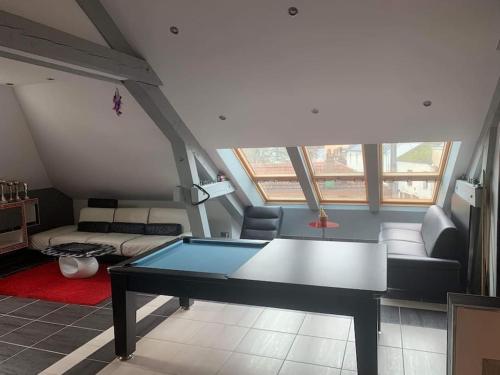 een woonkamer met een tafeltennistafel. bij Appartement moderne in Remiremont