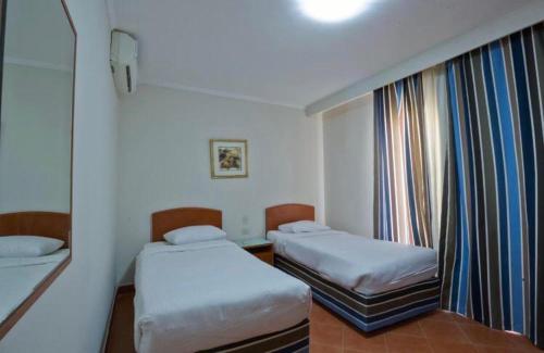 um pequeno quarto com 2 camas e uma janela em Hotel apartments - porto el sokhna - family only em Ain Sokhna