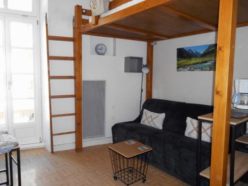 een woonkamer met een bank en een hoogslaper bij Appartement WIFI Monné centre Cauterets in Cauterets