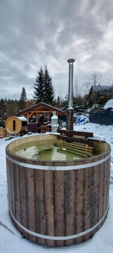 a hot tub in the snow next to a house at Chata na Orave so saunou a kúpacou kaďou in Námestovo
