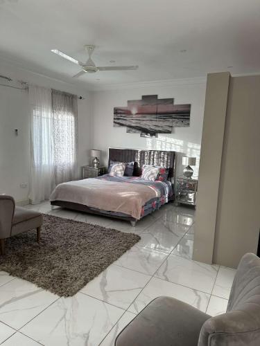 a bedroom with a large bed and a living room at Luxury 2 bedroom flat KerrSerign in Bathurst