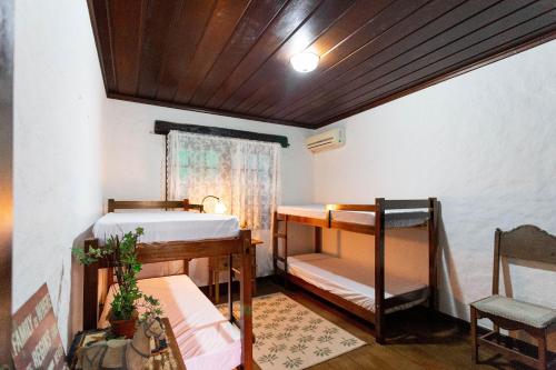 a room with two bunk beds and a table at Sítio com piscina, área arborizada e lazer in Jacareí