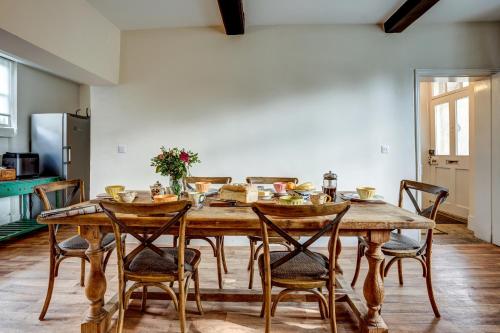 uma sala de jantar com uma mesa de madeira e cadeiras em The Bladon Farmhouse em Woodstock